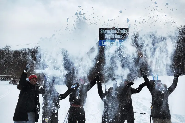 a group of people standing on top of a snow covered slope