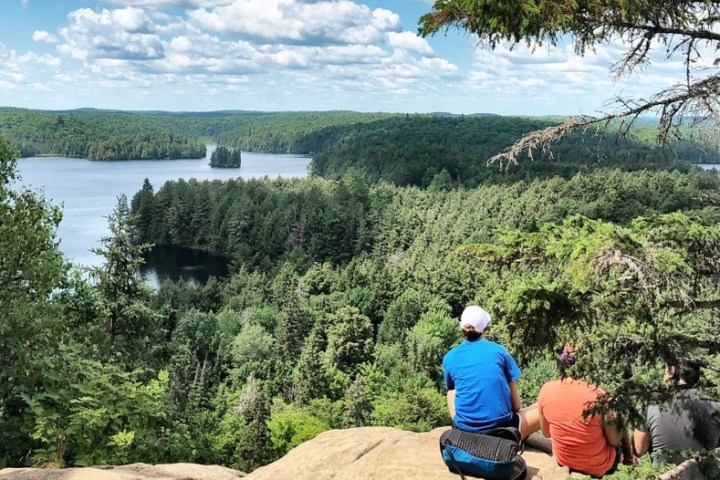 a man standing next to a body of water
