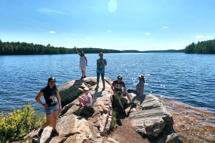 a group of people standing next to a body of water