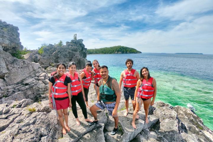 a group of people standing on a rocky beach