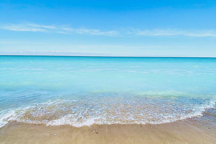 a group of people on a sandy beach next to the ocean