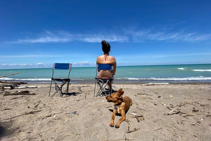 a man standing on top of a sandy beach next to the ocean