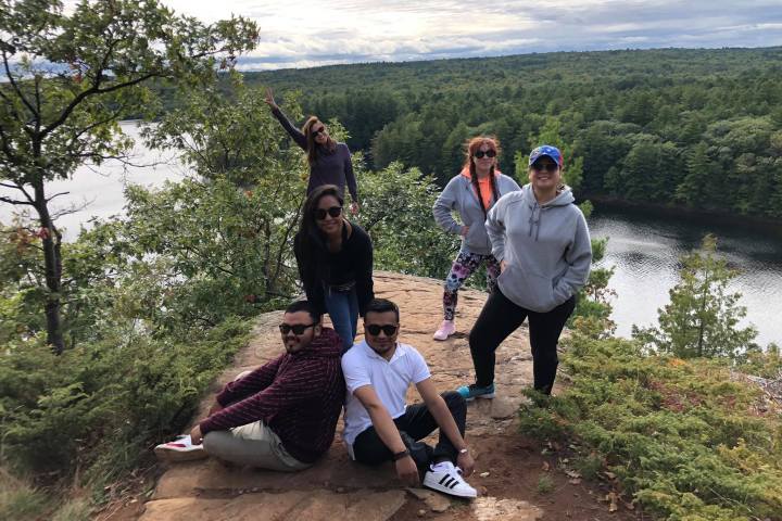 a group of people standing next to a tree