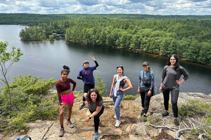 a group of people standing next to a body of water