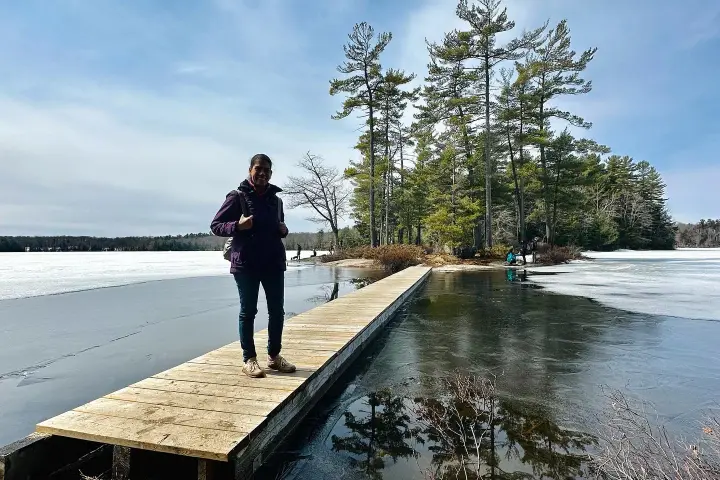 a person standing next to a lake
