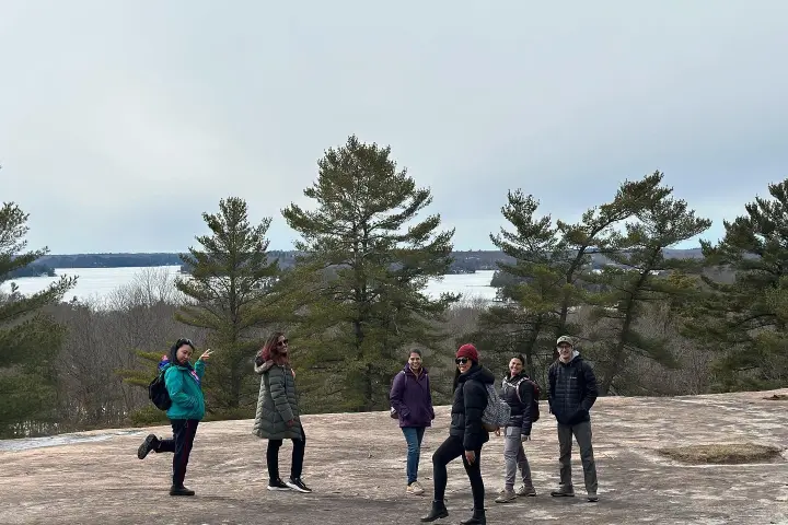 a group of people standing next to a tree