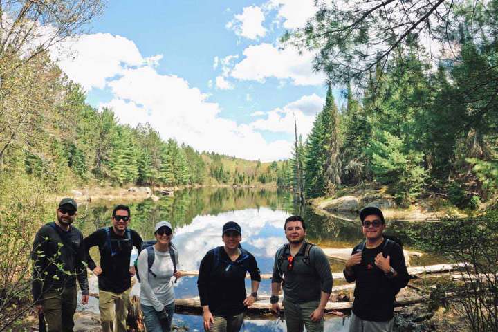 a group of people standing next to a tree
