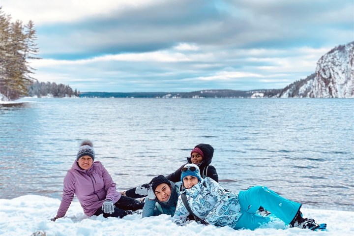 a group of people sitting next to a body of water