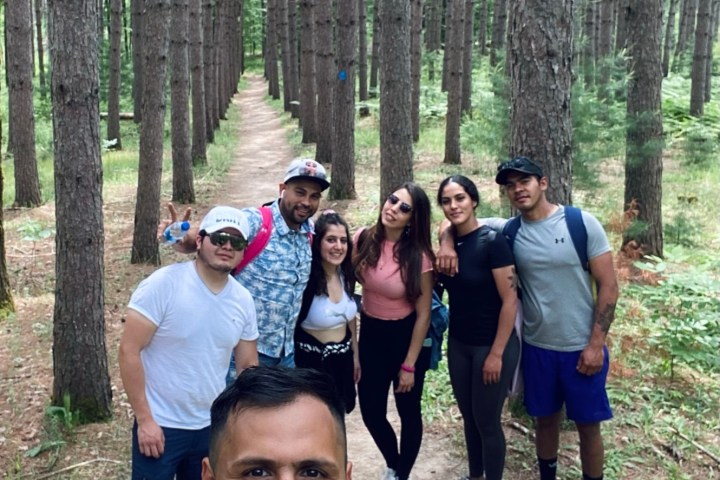 a group of people standing next to a forest