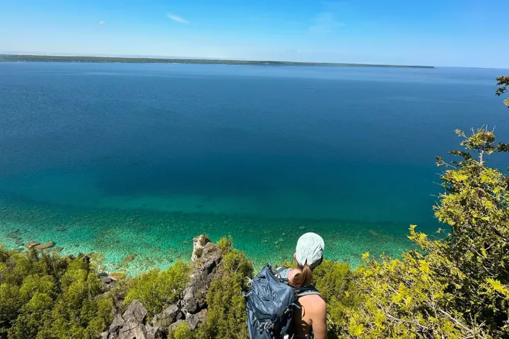 a man standing next to a body of water