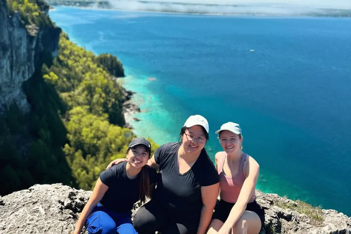 a group of people on a rocky beach next to a body of water