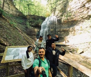 a group of people standing next to a waterfall