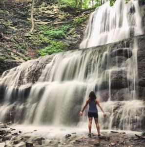 a man standing next to a waterfall