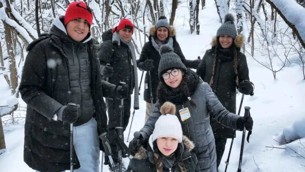 A group of people posing with their snowshoeing gears on