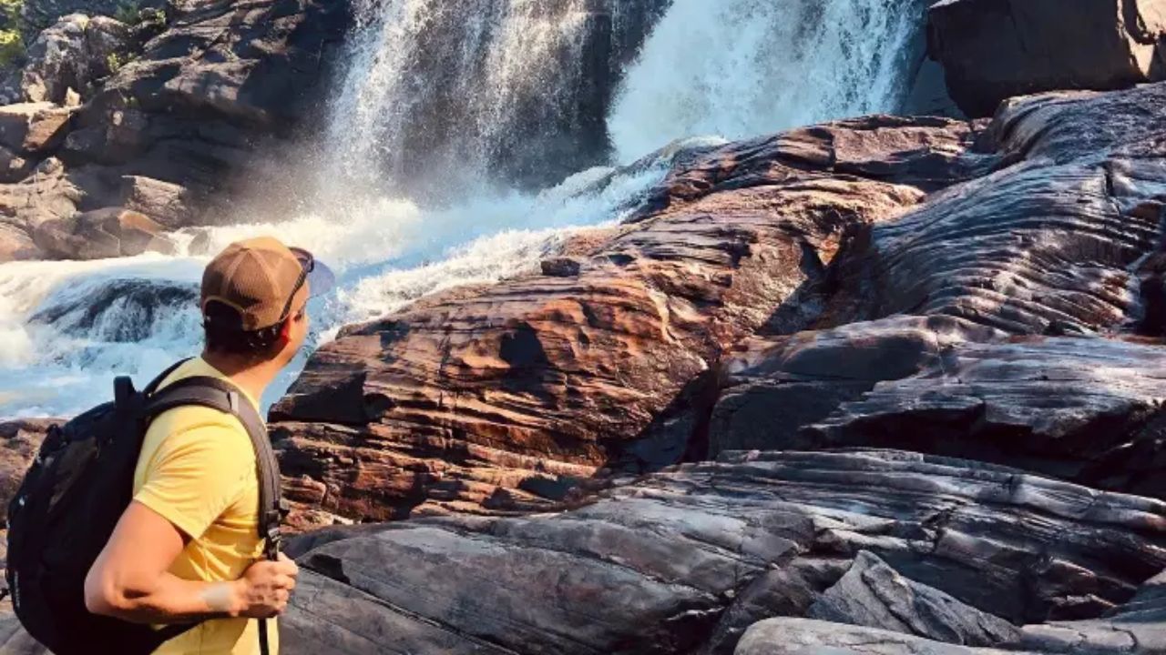 Hiker wearing a backpack standing on rocky terrain of Muskoka Adventure by Toronto EcoAdventures