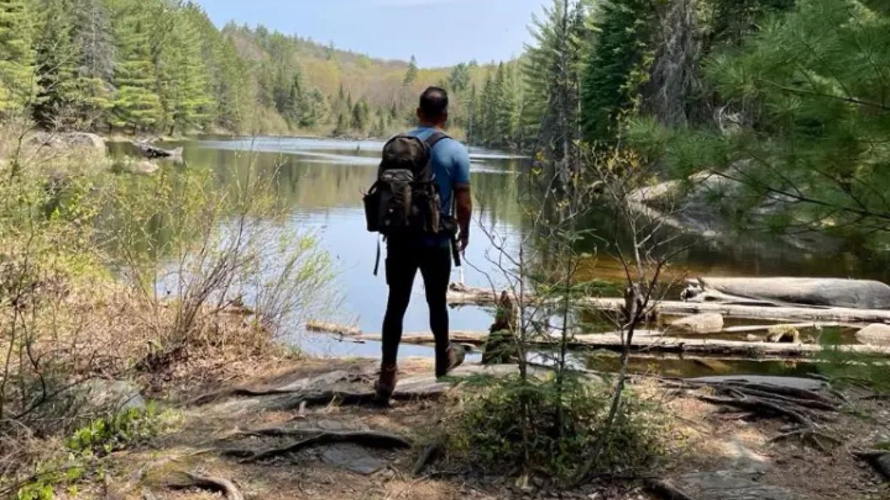 A woman with a backpack sitting on a rock at Muskoka Adventures
