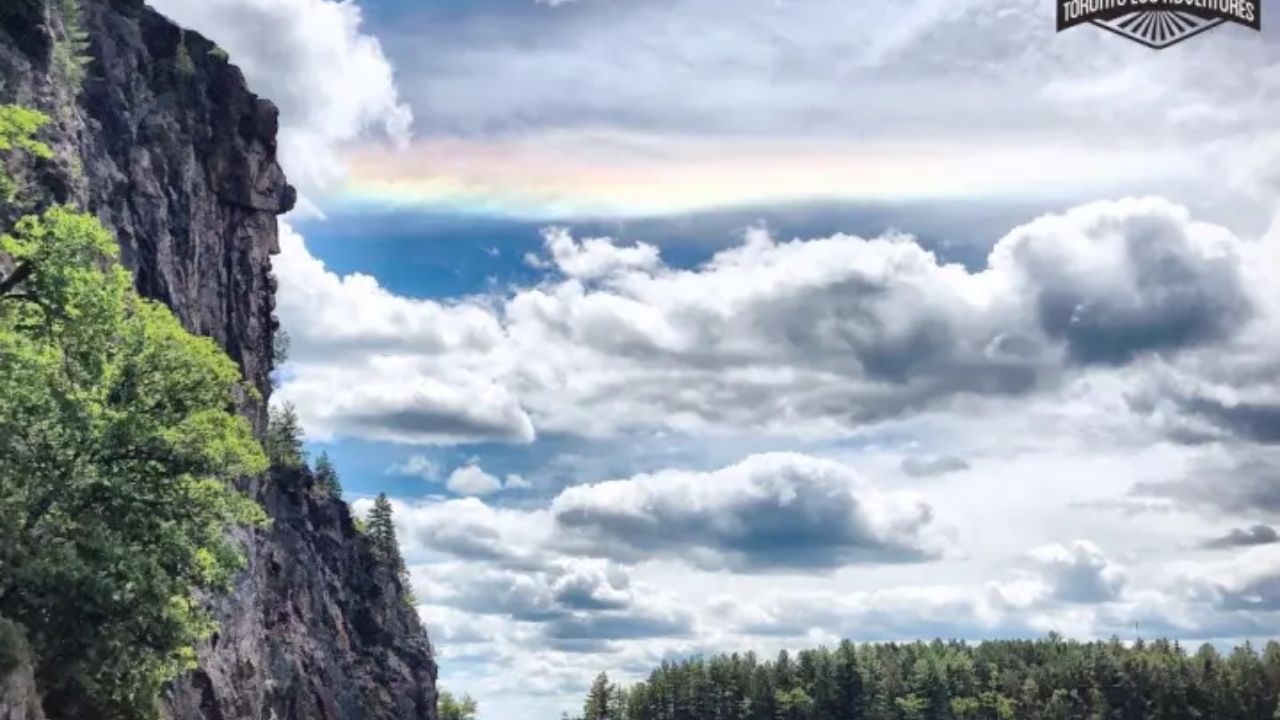 Dramatic landscape with cliffs, lake, and cloudy sky