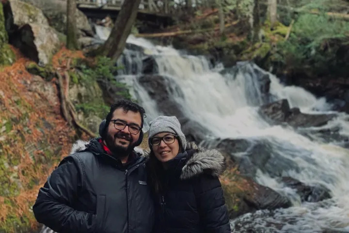 Couple posing beside a forest waterfall during a Muskoka nature getaway