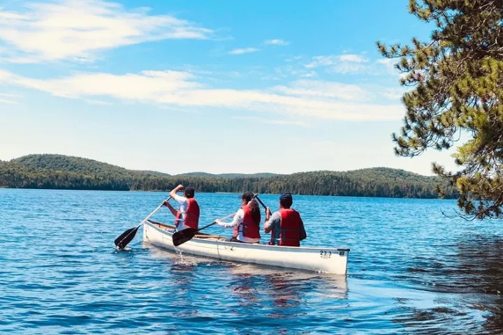 Group canoeing on scenic lake in Algonquin Park outdoor adventure