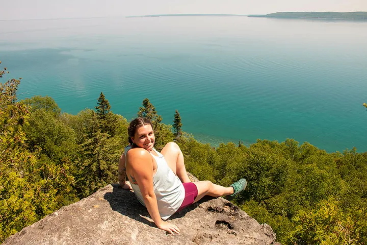 Hiker enjoying panoramic lake view from scenic Lion’s Head lookout in Ontario