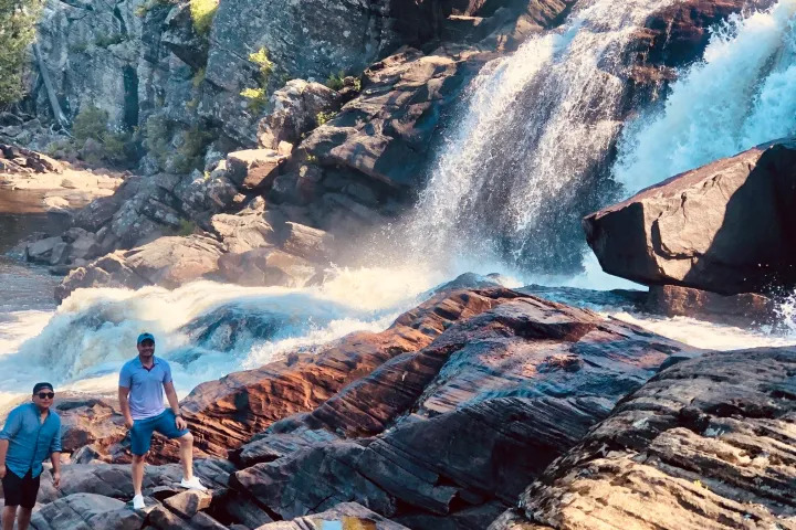 Visitors exploring rocky waterfalls and rapids in a scenic Muskoka wilderness area
