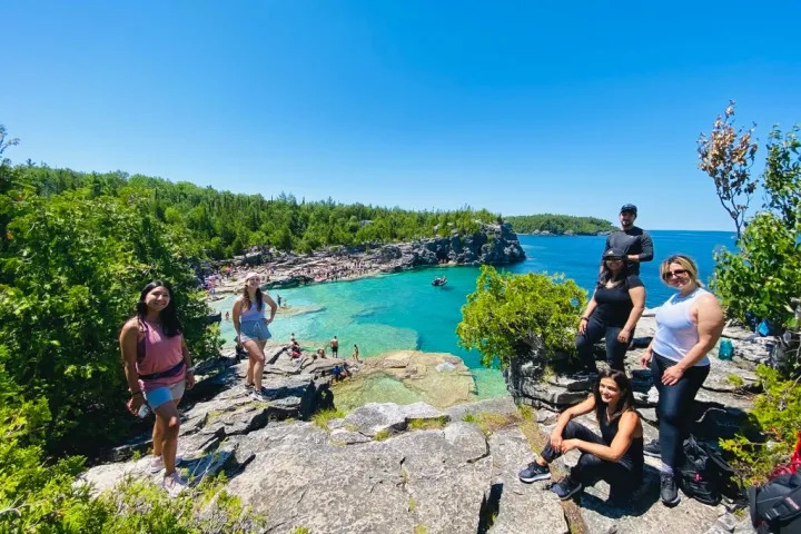 Group exploring a scenic Bruce Peninsula shoreline with turquoise water and rugged rock formations