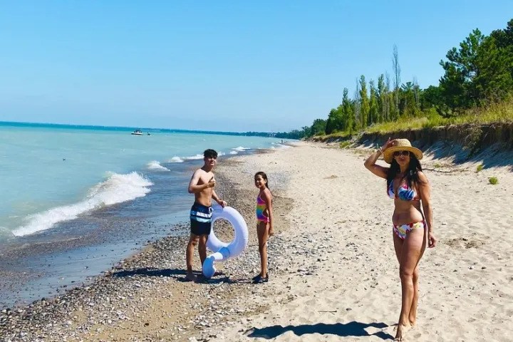 Family spending a sunny day walking and relaxing on the sandy shores of Grand Bend Beach, Ontario