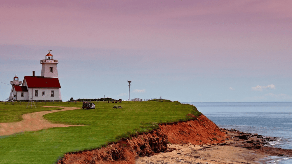 West Point Lighthouse on Prince Edward Island overlooking red sandstone cliffs and the Gulf of St. Lawrence.