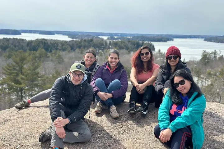 Group of hikers enjoying a scenic Ontario lake overlook.