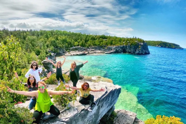 Group of hikers overlooking the turquoise waters of Bruce Peninsula National Park.