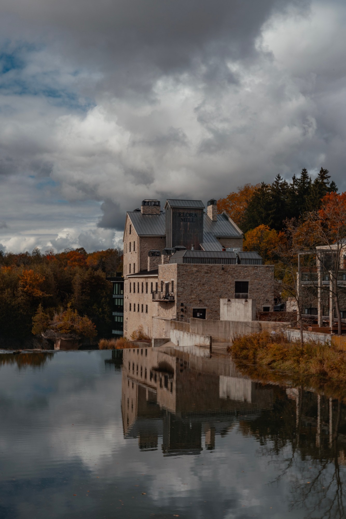 Historic Elora Mill overlooking the Grand River, surrounded by colourful autumn scenery in Elora, Ontario
