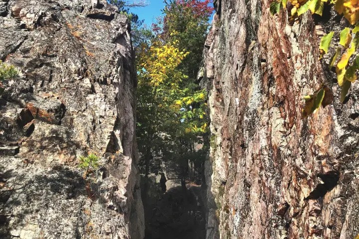 The Crack Trail surrounded by colourful autumn foliage along a rugged hiking trail in Killarney Provincial Park