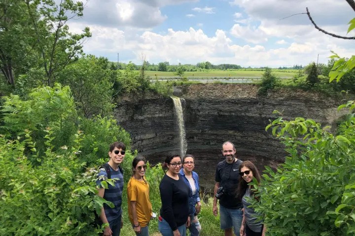 Visitors enjoying a scenic waterfall hike in a lush Ontario conservation area.